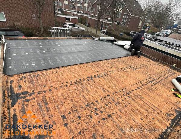 Dakdekker legt onderlaag op plat dak met houten constructie in Geldermalsen Dakdekker legt onderlaag op plat dak met houten constructie in Geldermalsen