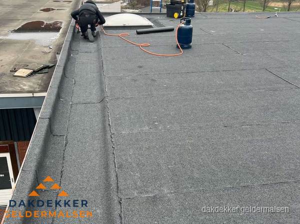 Dakdekker repareert bitumen dakbedekking op groot plat dak in Geldermalsen Dakdekker repareert bitumen dakbedekking op groot plat dak in Geldermalsen
